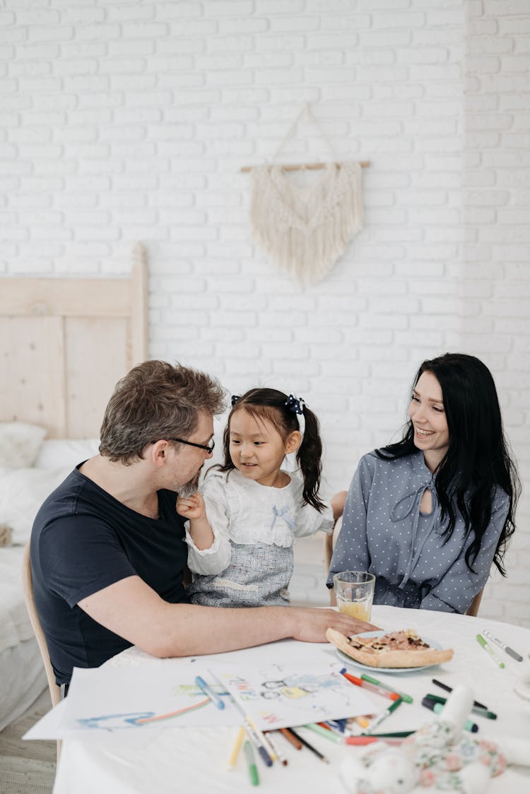 A Man And Woman Having Conversation With Their Daughter