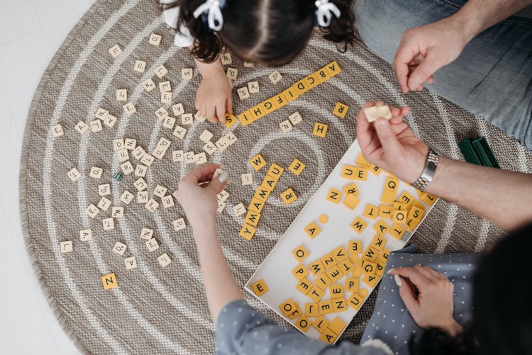 High-Angle Shot Of Family Playing Scrabble