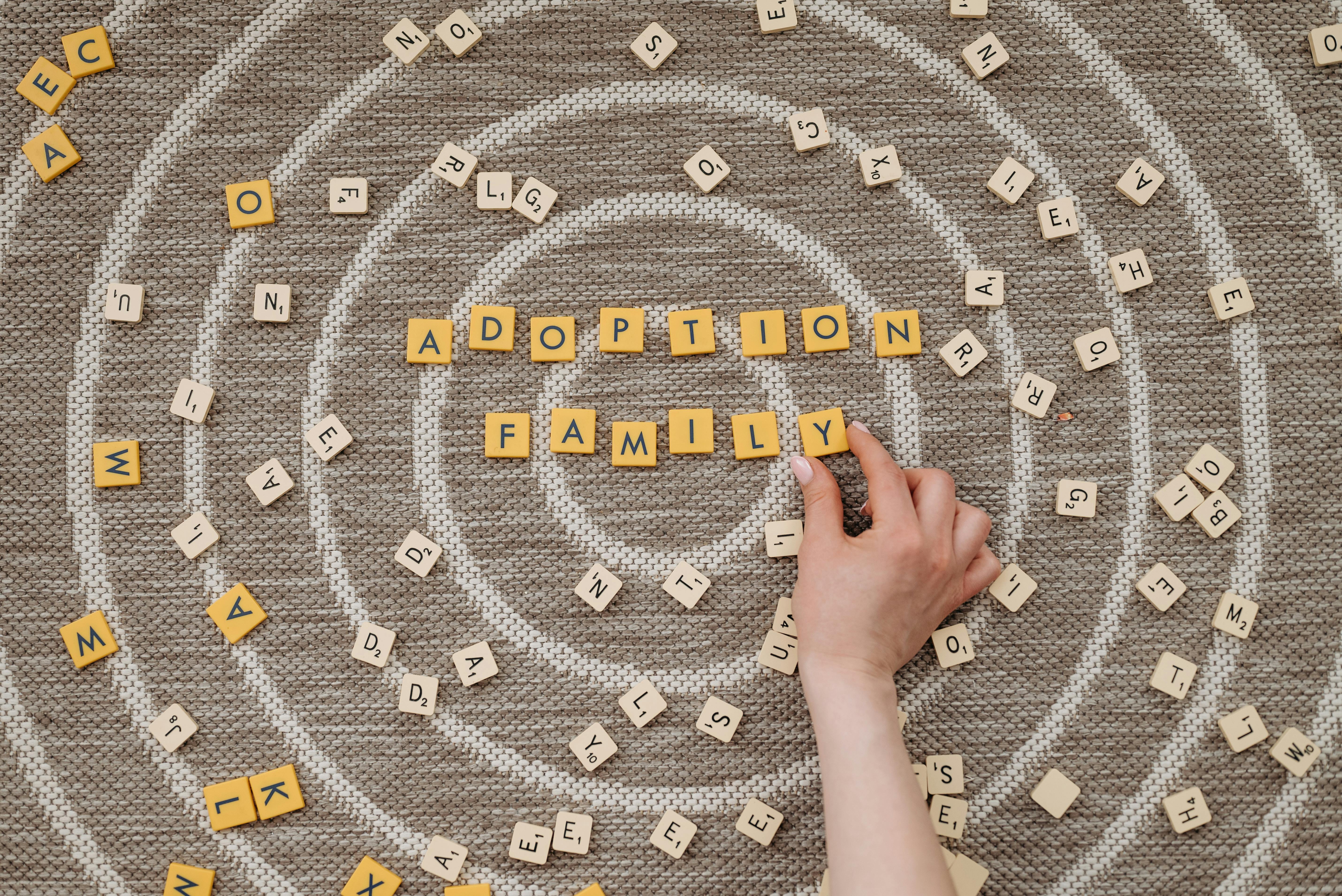 Free Person Holding a Scrabble Tile Stock Photo