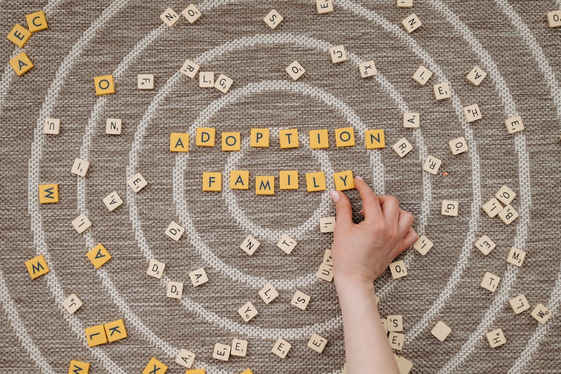 Free Person Holding a Scrabble Tile Stock Photo