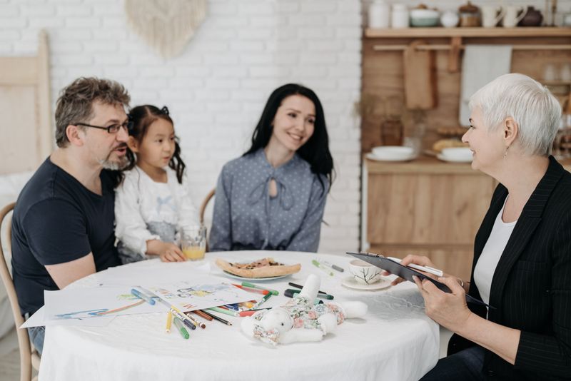 Adoptive family discussing with a social worker indoors