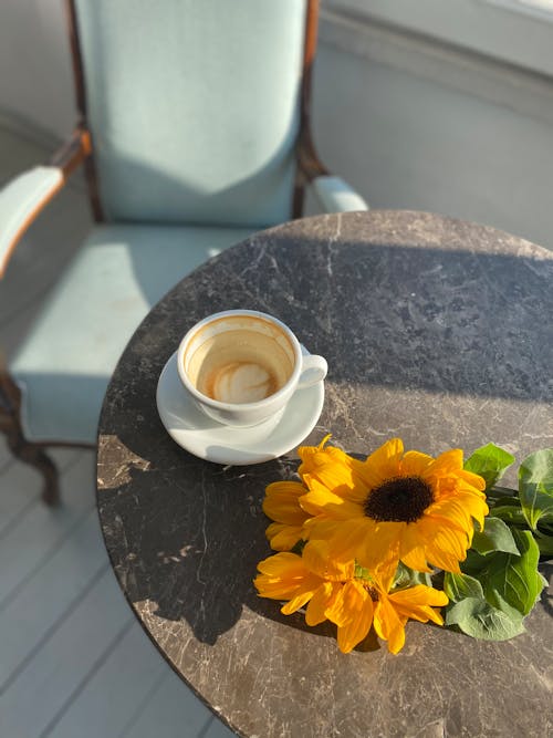 Free Empty Coffee Cup and Flowers on Table Stock Photo