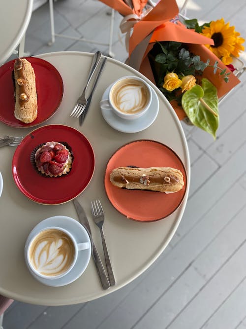 Brown Bread on Orange Plate beside Coffee on White Cup and Saucer