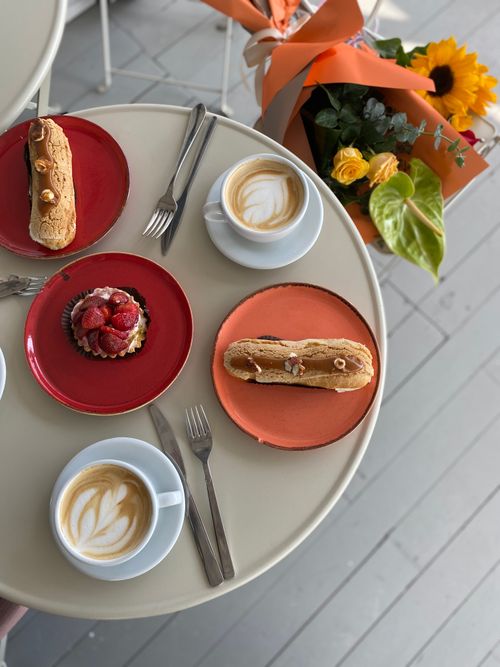 Free Top view of coffee and desserts on a table with bouquet of flowers. Stock Photo