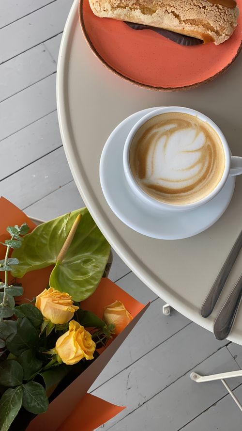 Free Top-down view of a cappuccino, pastry, and yellow roses on a table in Istanbul. Stock Photo