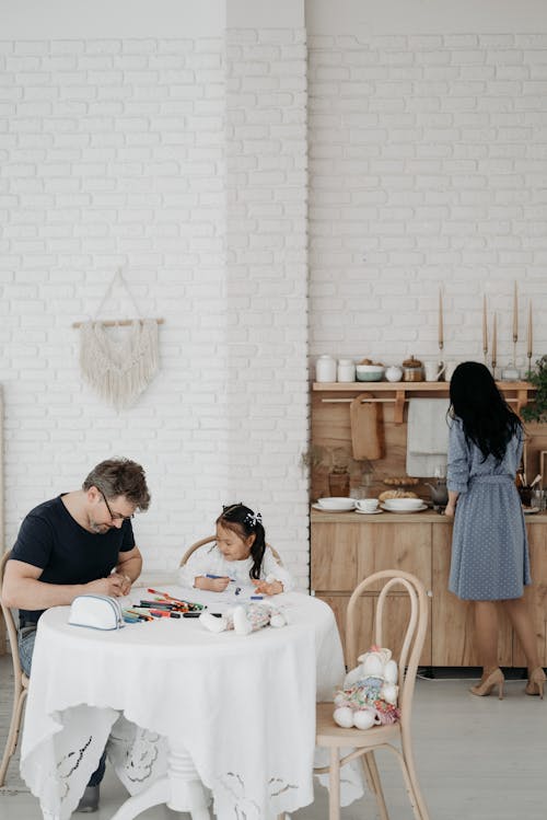 Free Father and Daughter Sitting on Chair in Front of Table Stock Photo