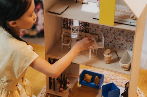 A Girl Playing a Doll House