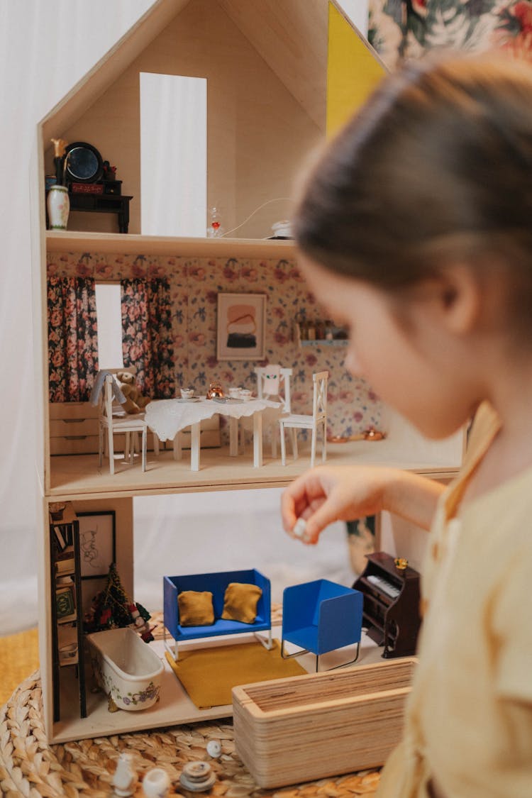 A Girl Playing A Dollhouse 