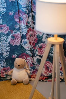 Charming interior scene featuring a stuffed toy and floral curtain in a cozy room setting.