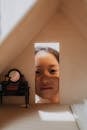 Girl Peeking Through a Doll House
