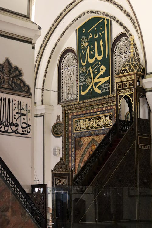 Interior of spacious classic mosque with ornamental details on walls with arched elements in daylight