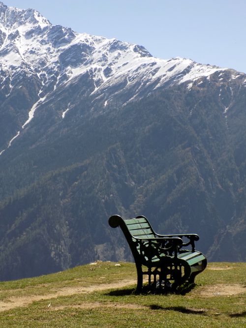 Free A serene bench overlooks the snow-capped mountains in Auli, India, offering a tranquil outdoor scene. Stock Photo
