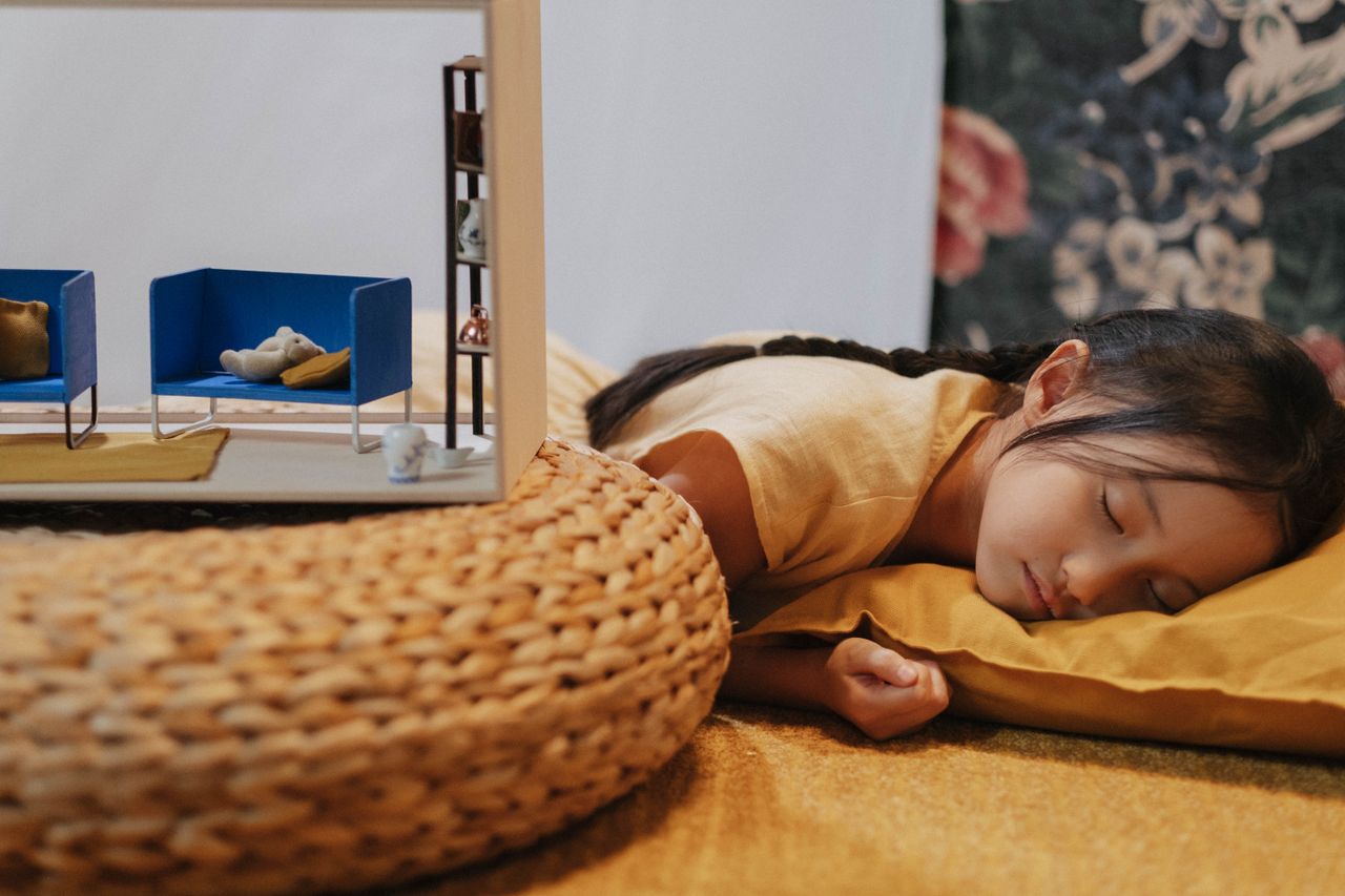 a young girl sleeps peacefully on a cushion indoors showcasing a seren