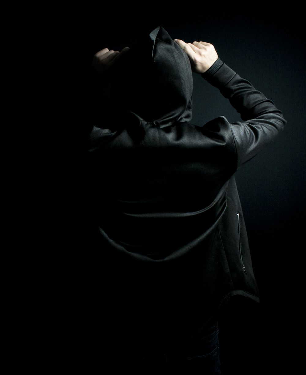 Silhouette encapuchonnee en studio, veste noire mate — photo MEHRAX on Pexels