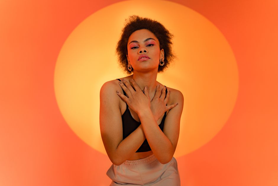 Portrait against a vivid orange backdrop — Adventure Studio on Pexels