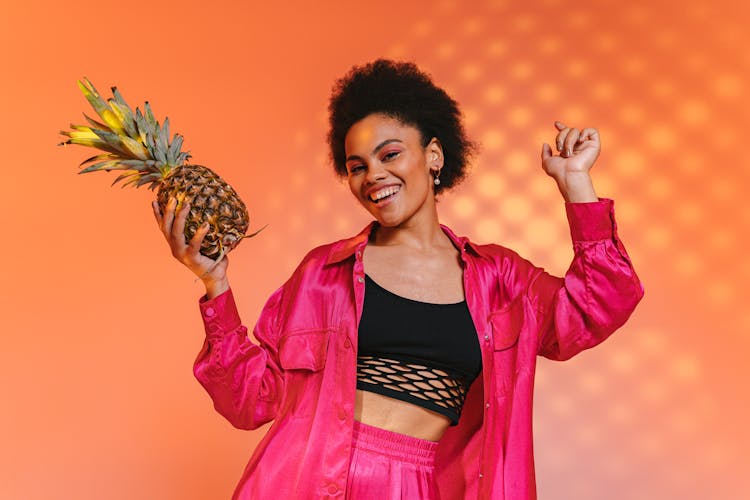 Woman In Pink Jacket Holding Pineapple