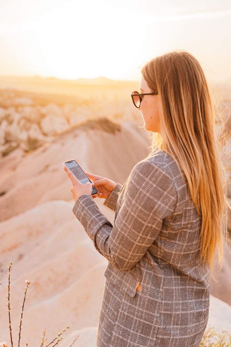 A Woman In Plaid Blazer Using Her Mobile Phone