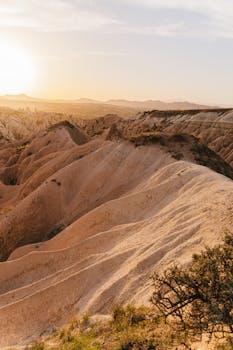 Stunning aerial view of Cappadocia's unique rock formations during a golden sunset.
