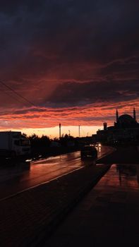 Capture of a dramatic sunset over Istanbul street with silhouette of a mosque, creating a vibrant urban scene.