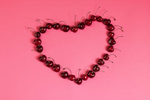 Cherries Arranged in Heart Shape on the Pink Background
