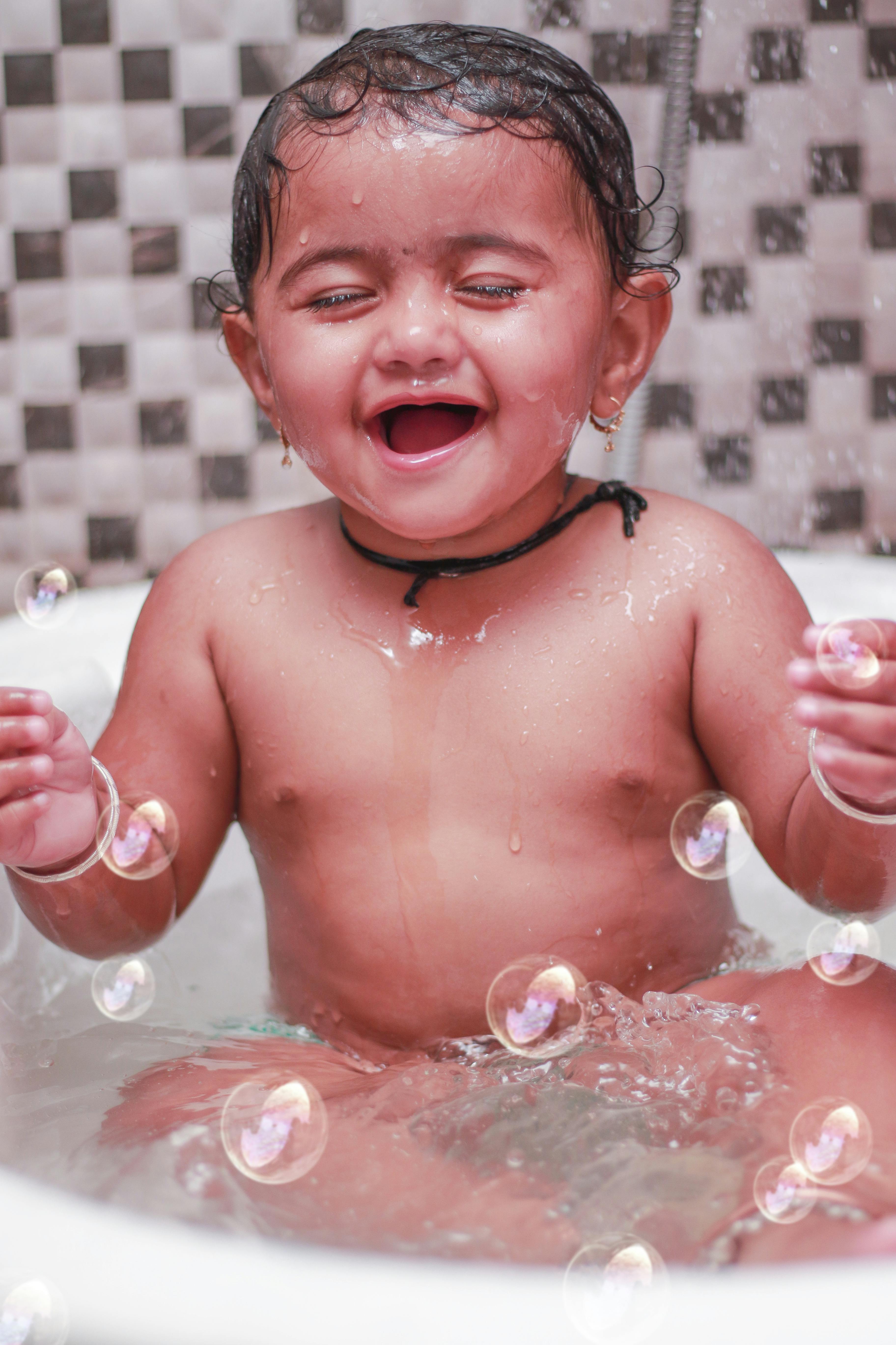 A Baby Sitting in the Bathtub · Free Stock Photo