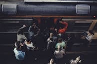 从鸟瞰视角看，一群通勤者在车站登上火车