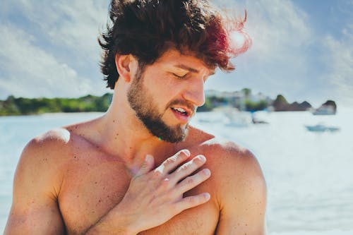 Topless Man in Front of Body of Water