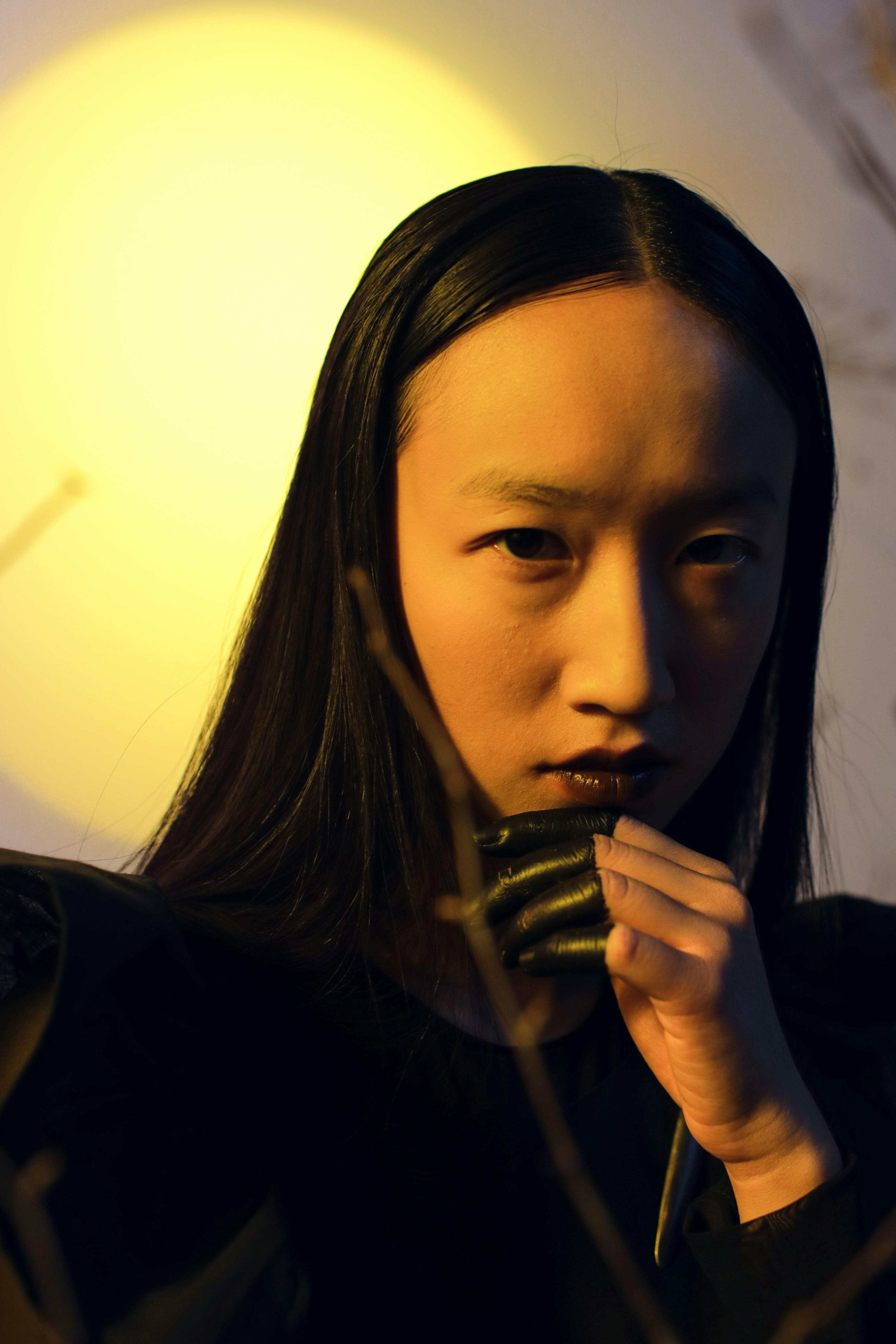 Moody portrait of a woman in dramatic lighting, showcasing elegance and mystery.
