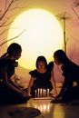 Women Sitting on the Floor while Looking at Candles