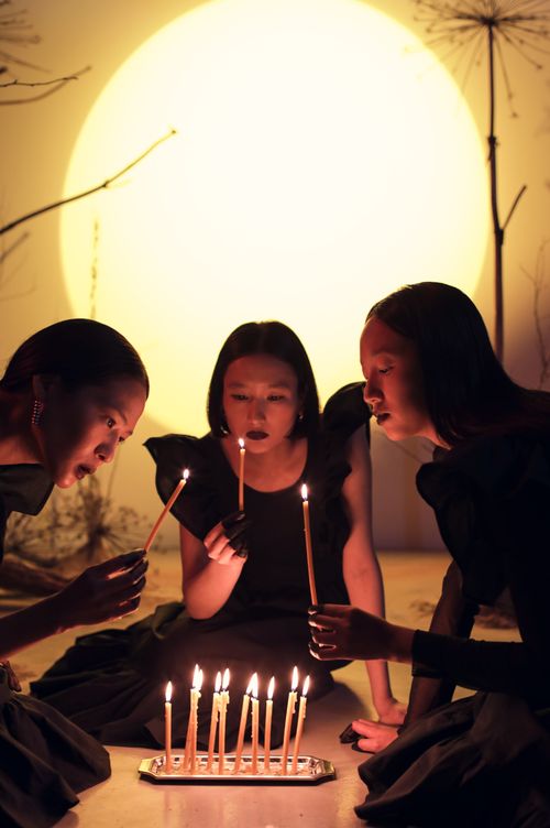 Free Three women gather around lit candles, creating a serene and thoughtful atmosphere. Stock Photo