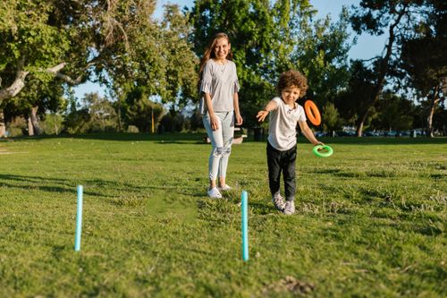 Free A joyful moment as a mother and son play with rings in a sunny park. Stock Photo