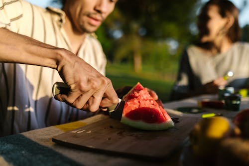 Free Man Slicing Watermelon on Brown Wooden Chopping Board Stock Photo