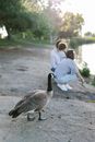 Man and Woman Sitting on Rock Near Lake