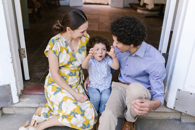 Little Boy Telling His Parents His Adventures Sitting On The Doorstep