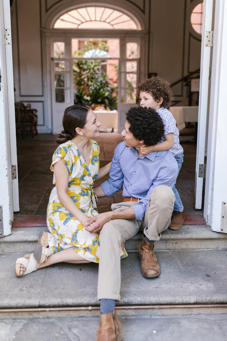 A Family Sitting At The Doorway