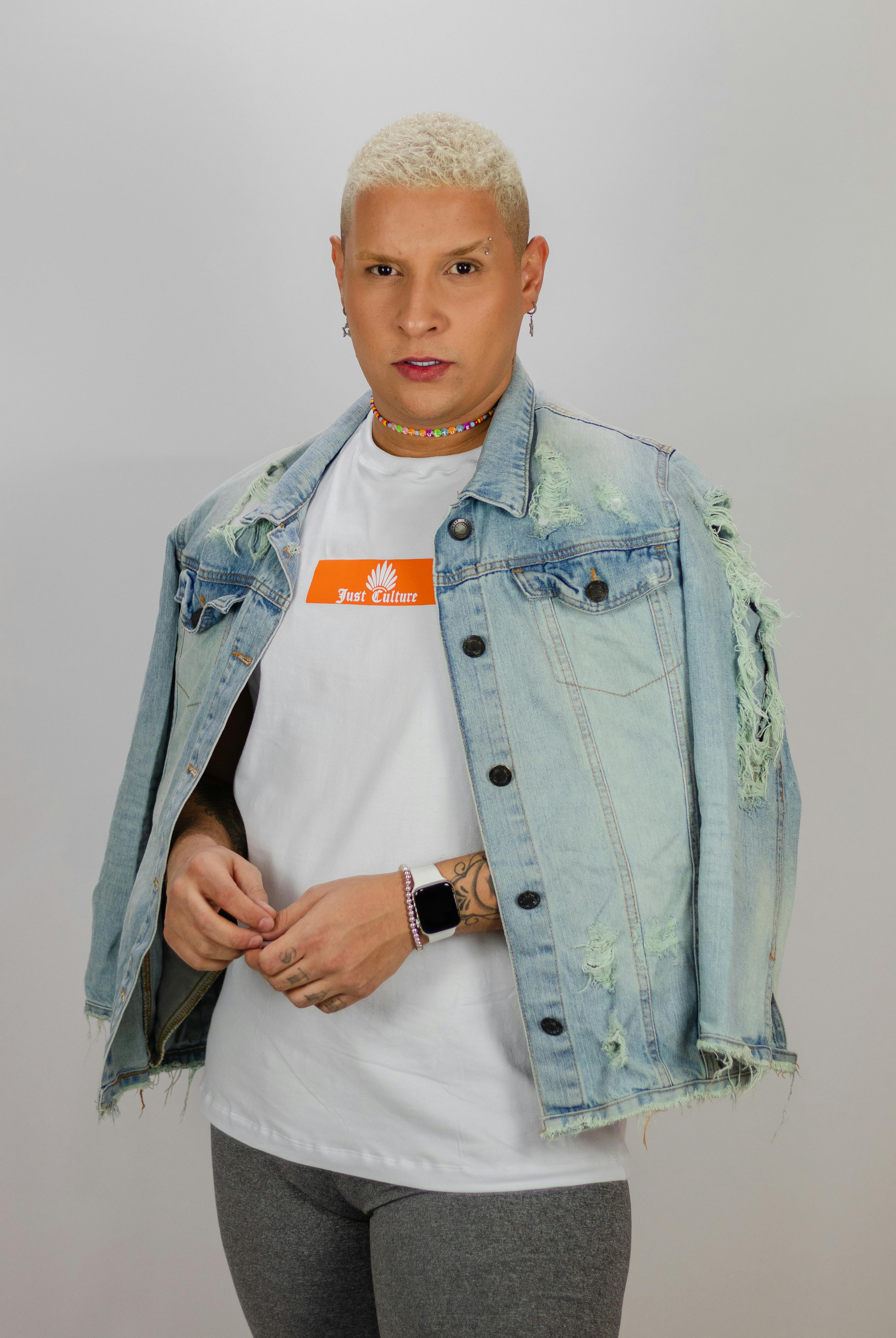 Fashionable male model wearing a denim jacket, trendy outfit on white background.