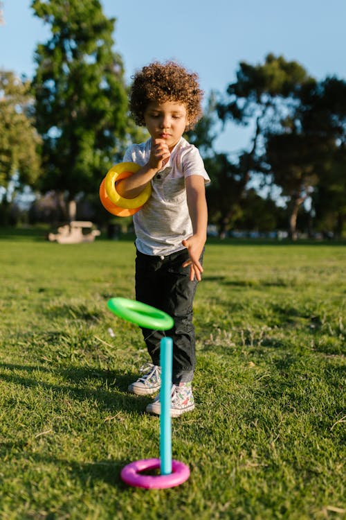 A Boy Playing Ring Toss in a Park 