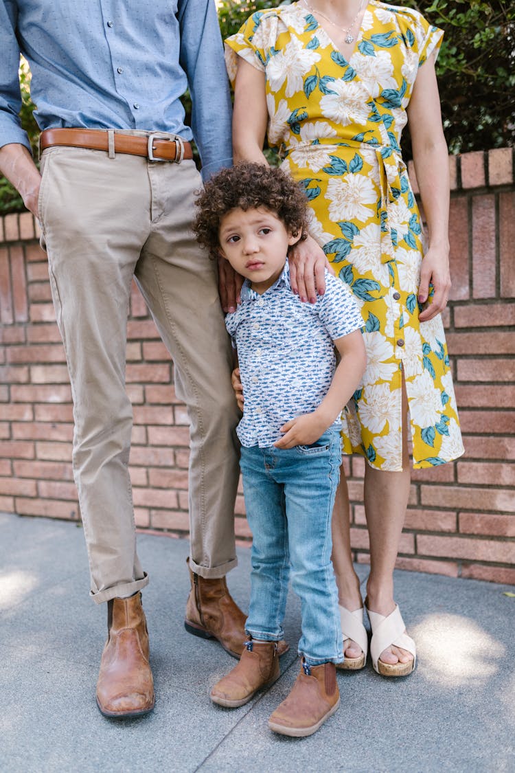 Little Boy With Curly Hair Standing Together With His Parents