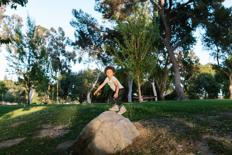 Little Kid Climbing On The Rock