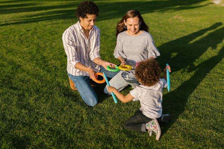 Parents Playing With Their Son At A Park