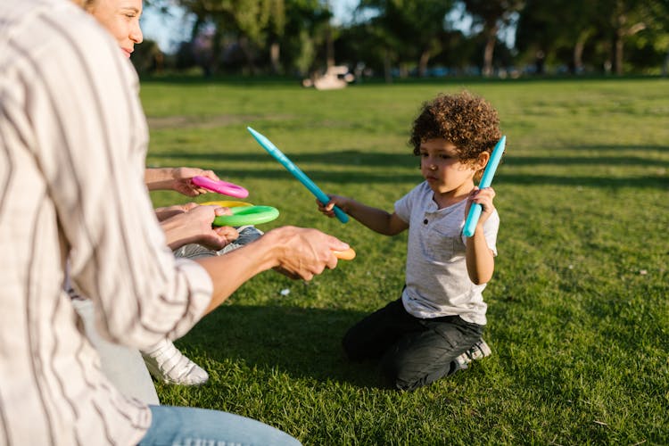 Little Boy Playing With His Parents In The Park