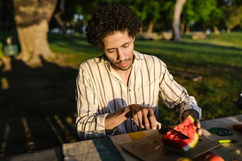 A Man Cutting a Watermelon