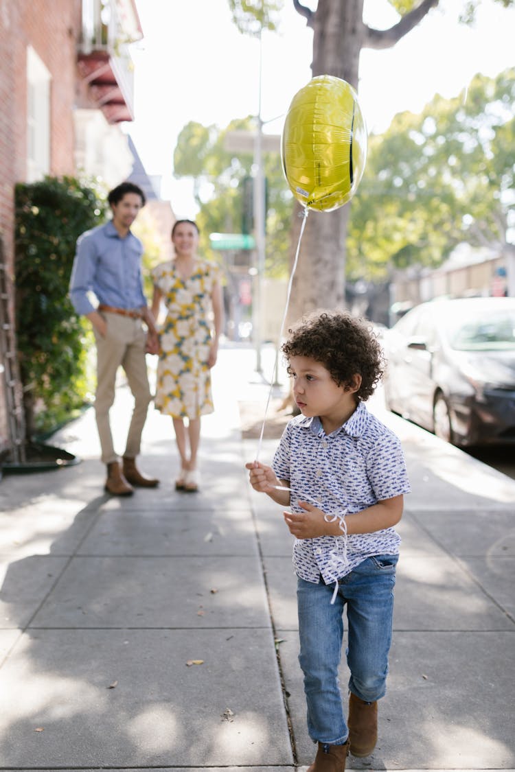 A Young Boy Holding A Balloon