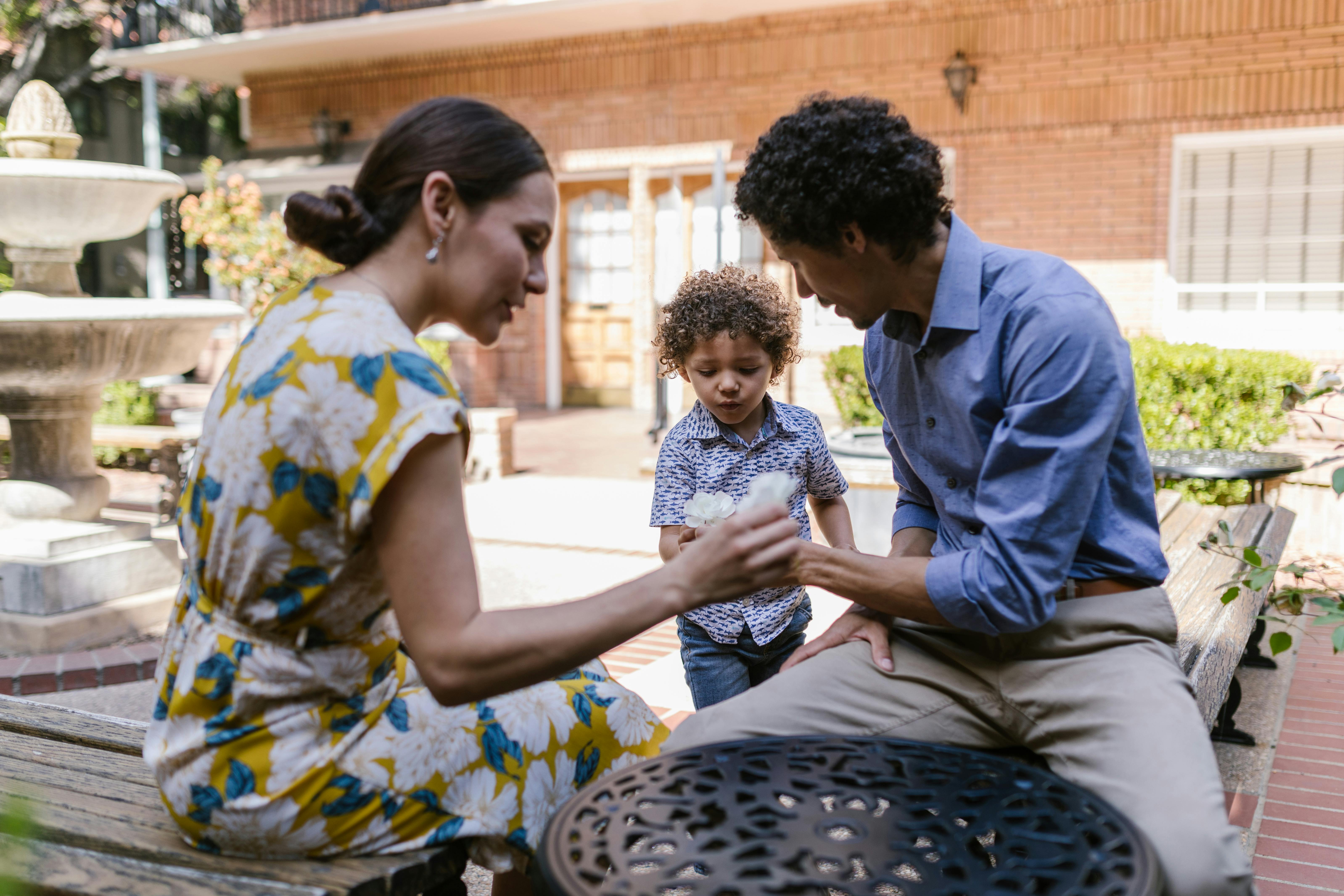 family with a little son sitting near a fountain