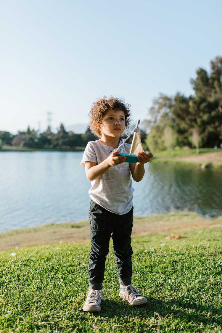 Boy Holding A Toy Boat