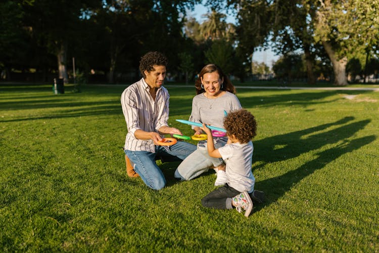 Parents And Son Playing Ring Toss In A Park In Summer 