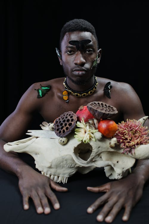 Man Holding an Animal Skull with Flowers 