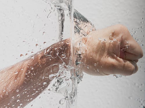 Person's Left Fist Punching Water