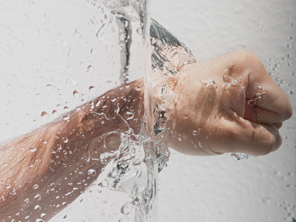 Free Person's Left Fist Punching Water Stock Photo