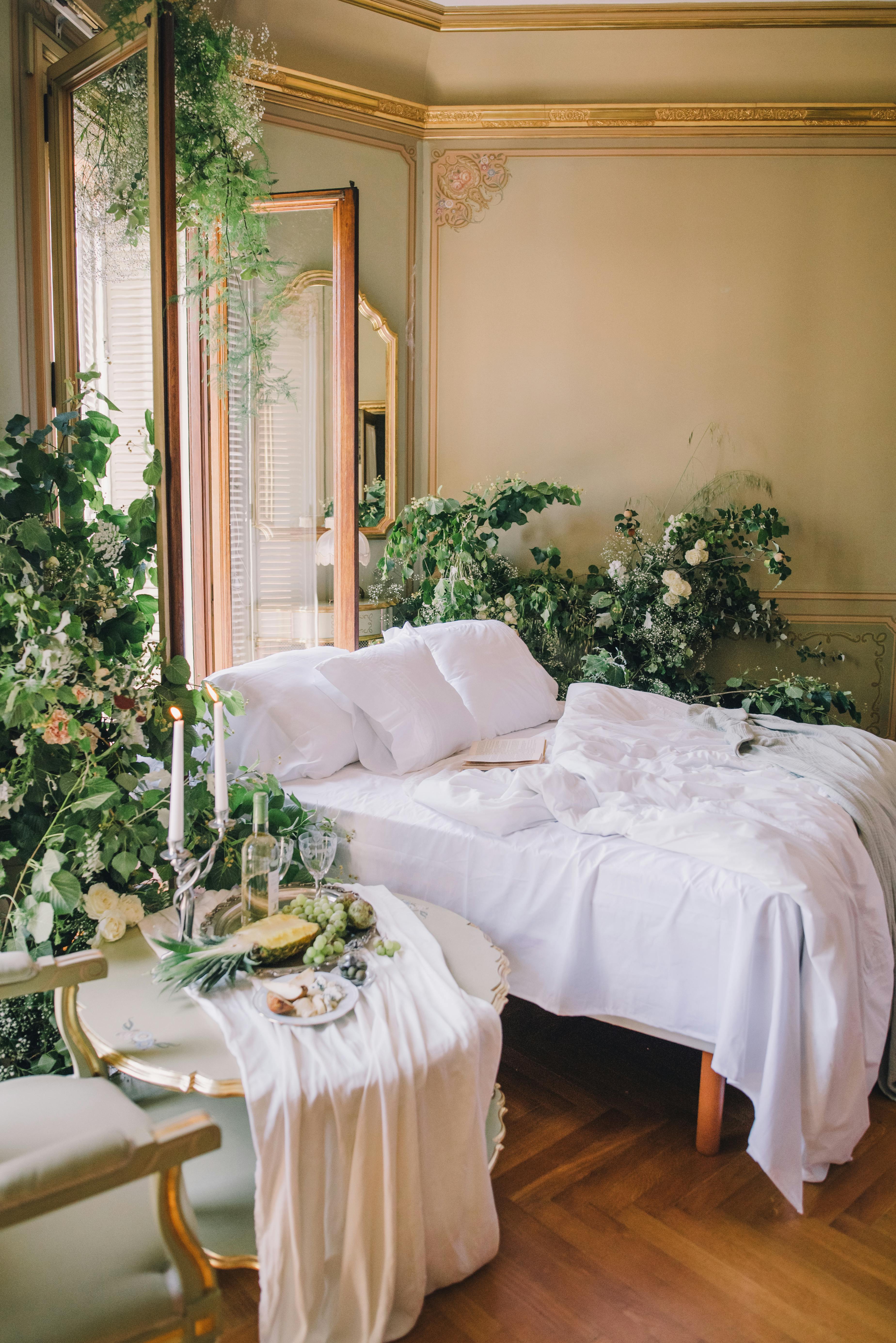 Opulent bedroom adorned with lush greenery and sophisticated decor, creating a serene atmosphere.